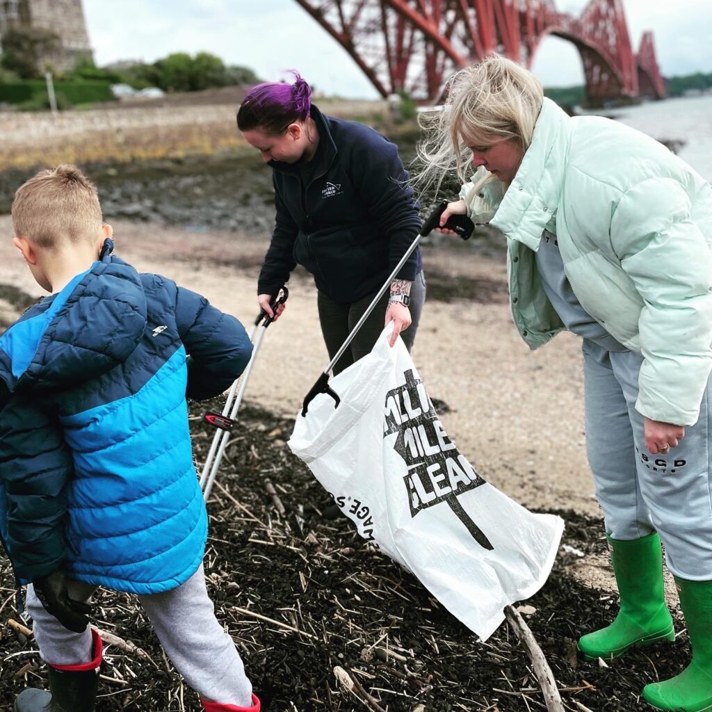 One of our Deep Sea World staff members alongside volunteers picking up rubbish.