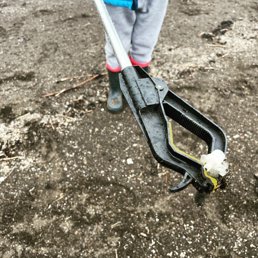 One of our volunteers holding a plastic covid test found on the beach.